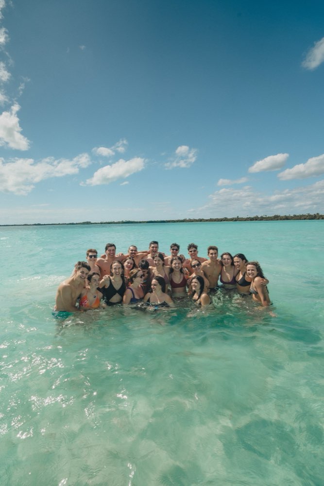 Grupo de universitarios de Versity en el agua turquesa en México